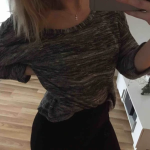  - Stickad gråvit tröja från Atmosphere London med korsade band i ryggen. Passar en S/M.