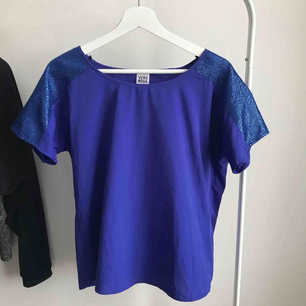 En finare t-shirt från Vero Moda med snygga detaljer på axlarna, små små paljetter. Jättefin blå färg, endast använd fåtal gånger. Köparen står för frakt. T-shirts.