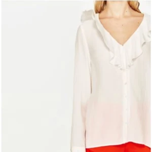  - Vit blus med knäppning och volang urringning från Zara. Strl XS 