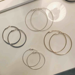  - Fyra par örhängen. Två stora i silver och guld. Ett lite mindre i silver och ett som är lite tjockare och tyngre än dem andra. Alla för 80 kr eller 30 kr/st. Betalning med swish