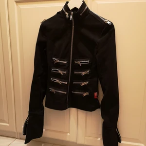 Jacka - I väldigt bra skick, två inre och tre yttre fickor, 17 stora blixtlås. Från axeln och ner (längd) är den 56cm och från axel till axel (bredd) är den 42cm. Ärmarna är längre.