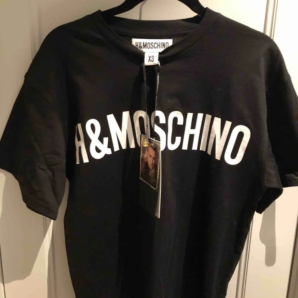 Helt oanvänd T-shirt från MOSCHINOs samarbete med H&M. Ett av de plagg som sålde slut direkt! Storlek XS fast herrmodell så snarare en S i dam. . T-shirts.