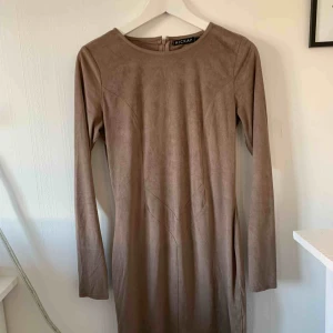  - Figursydd klänning i brun/mörkbeige färg. Supersnygg till festtillfällen bland annat:) extremt bekväm för att vara en sådan typ av klänning. Använd på nyår för ett par år sedan och fick många komplimanger. Framhäver verkligen former:)