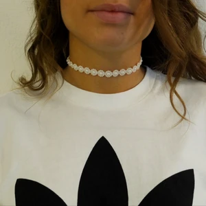 Pärl-halsband  - Egengjort halsband i plastpärlor formade som små blommor, ställbar storlek