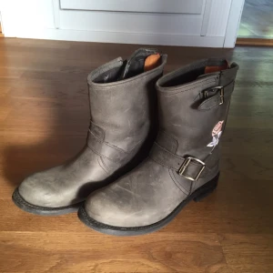  - Helt oanvända Primeboots!! Gråa med en blekrosa blomma vid hälen på båda skor. 