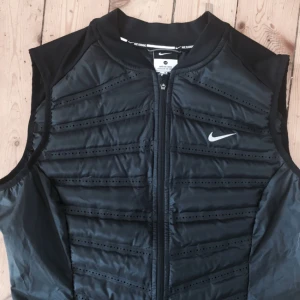  - Oanvänd Nike damm dunväst i storlek Medium.