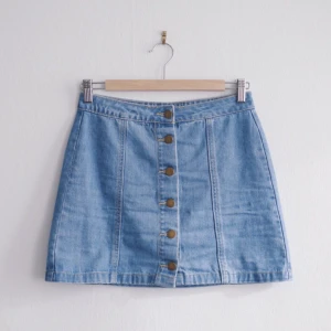  - Kort jeanskjol från Forever21 med knappar framtill. 

Mått: omkrets ca 70 cm, längd 37 cm. 