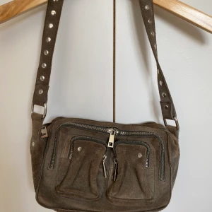 Nunoo väska - Sjukt fin och populär nunoo väska. Den uppfattas mer mörkgrå i verkligheten. Kommer med även ett längre band.