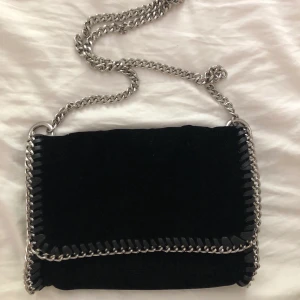 Väska - Säljer en Stella McCartney INSPIRERAD väska från Gina Tricot. Helt oanvänd, alltså nyskick. Säljer för 100kr, frakt på ungefär 80kr tillkommer. (Tuggummipaket för att visa ungefärlig storlek) materialet är lite sammets-aktigt.