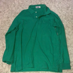 Fila pike tröja - En vintage fila pike tröja i en skön grön färg. Oanvänd och väldigt fint plagg dock är fila loggan svår att se. Storleken ligger runt en m-L (köparen står för frakt)