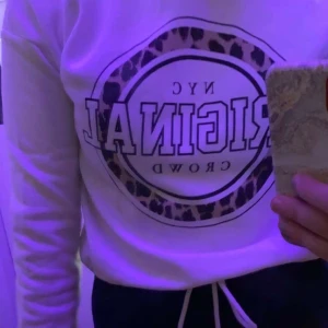 Vit hoodie med knytning - Vit hoodie med tryck fram och knytning längst ner vilket framhäver midjan väldigt fint 60kr + frakt 