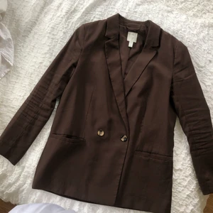 Brun kavaj - Snygg kavaj från Hm. Använd men fortfarande väldigt fint skick. Står 40 men jag som har 38 har använt den som lite oversized.