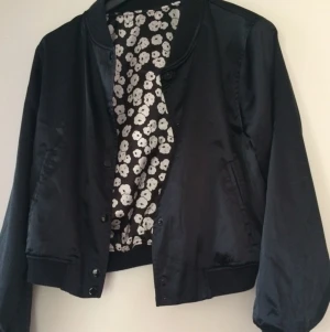  - Snygg jacka med glansigt tyg från Monki.
Jackan går att använda på båda sätten.
Stängs med knappar.
Otroligt snygg som innerjacka under vinter / höst och perfekt som utomhus jacka under vår och sommar.
Frakt tillkommer.
