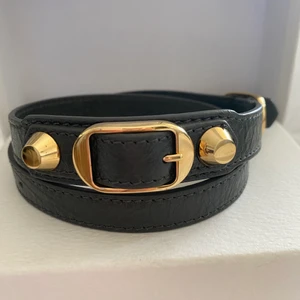 Balenciaga armband  - Grått balenciaga armband med guldiga detaljer i storlek S, använt Max 3 gånger men det ser helt oanvänt ut. Dustbag och låda tillkommer. Såklart äkta!!! Kan mötas upp och frakta. Kan också bytas mot ett valentino armband i bra skick!