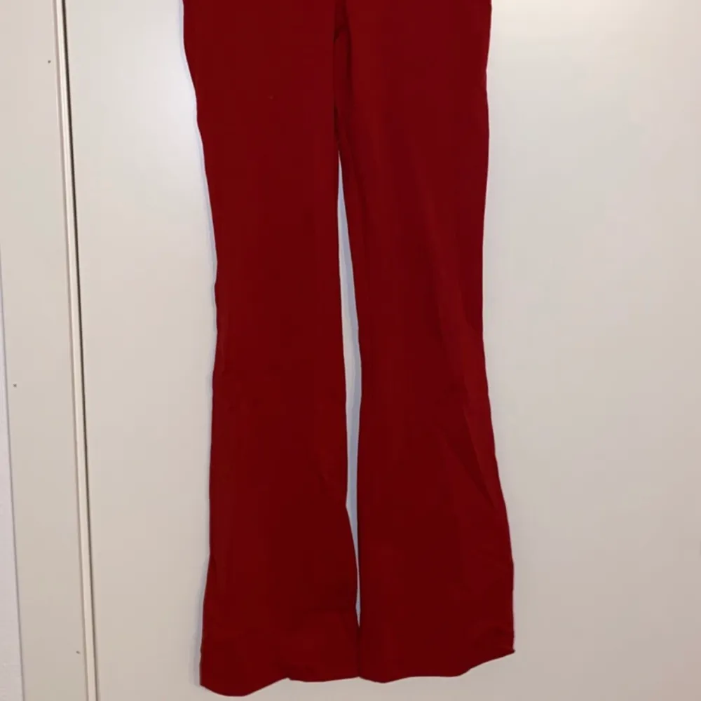 Ett par röda utsvängda byxor i storlek 150 men passar en xs.. Jeans & Byxor.