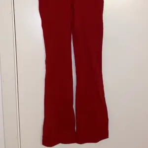 Ett par röda utsvängda byxor i storlek 150 men passar en xs.