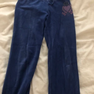 Juicy Couture byxor, mörkblå med detalj - Juicy Couture byxor som är mörkblå och tillhör ett set (tröjan är borta). Bra skick och endast använd fåtal gånger och är ganska små i modellen.                 Storlek XL i barnstorlek så skulle säga 170 i svensk barnstorlek          EXCLUSIVE FRAKT