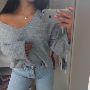 Grå stickad tröja - Stor v-ring som går att ha på olika sätt, skönt material. Använd men fint skick.💕