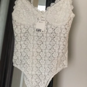 Vit body - Oanvänd vit ”virkad” body i xs med bra stretch. 