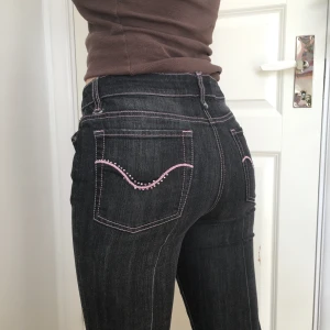 Svarta raka/bootcut jeans - Rosa sömmar och detaljer på fickorna, storlek 40 men passar mindre (stretchiga)! Jag är 167cm och har ca W29. Har lagat ett hål på sidan (bild 3) Frakt tillkommer...