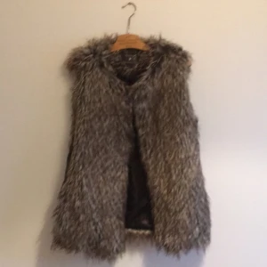  - Väst i fuskpäls från Forever 21 med skinnimitation på sidorna. Använd 2 ggr. Saknar ett band i midjan som tillhörde men försvann! 
Köparen står för frakten.