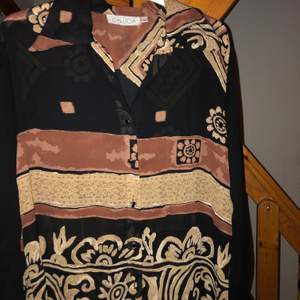 Lång tunika med unikt mönster i stl L. Sitter snyggt på en s/m. 