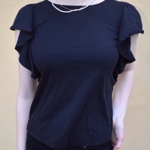 Topp med volang ärmar  - Topp med volang-ärmar från uniqlo.🖤