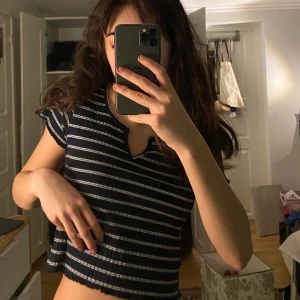 Ribbad Topp  - Elastisk topp i blått och vitt. Tips är att ha den med lågmidjade byxor. Tröjan är i toppskick.