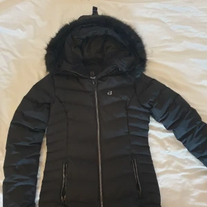 Svart dunjacka  - Ny svart dunjacka från 8848 Altitude.  Storlek 38 med en smal passform. Två ytterfickor och en innerficka. Dragkedja som går att knäppa långt upp. Vattentät 10 000 mm. Vindtät. Nypris 2199kr. 