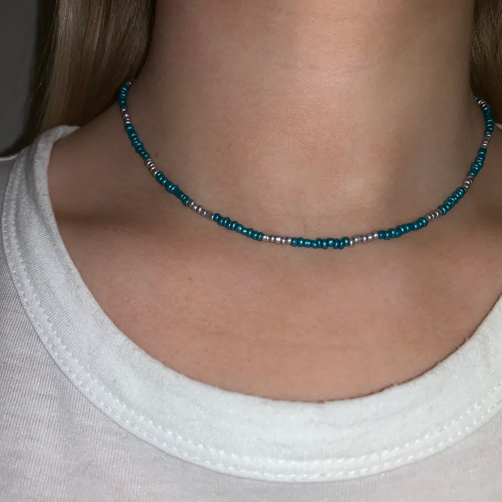 Silvrigt och blått pärlhalsband med små pärlor💙⭐️🥺🦋💫🌙 halsbandet försluts med lås och tråden är elastisk . Accessoarer.
