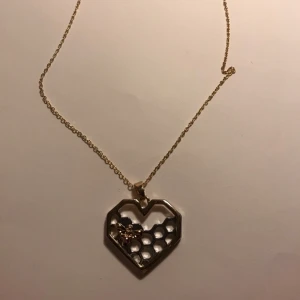 Guld halsband  - Guld halsband med en jätte gullig berlock. En hjärt formad bikupa med ett bi på. Berlocken är guldig och silvrig.
