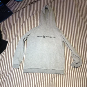 Grå Sailracing hoodie storlek 150 - Grå Sail racing hoodie äkta ifrån kidsbrandstore. I väldigt bra skick, säljer för den har blivit för liten för mig. Original pris: 599kr.