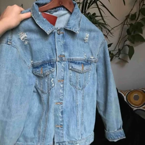 - Jeansjacka med knytning i ryggen. Använd fåtal gånger och har lite smuts vid ena axeln men syns knappt