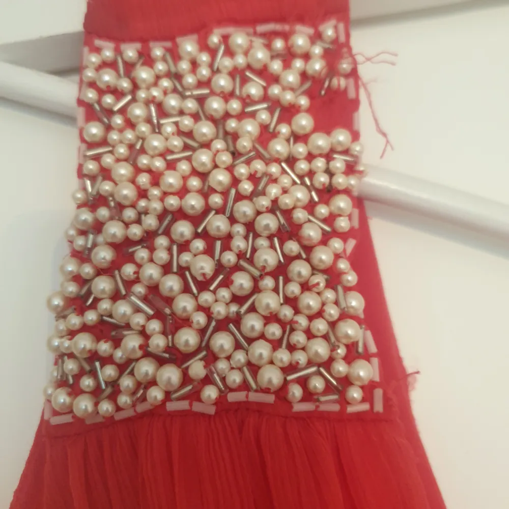 Vacker klänning i en rödaktig färg med pärlor upp till. Storlek: small Märke: vila Endast använd 1 gång som ny! Köparen betalar frakten. Har swish.. Klänningar.