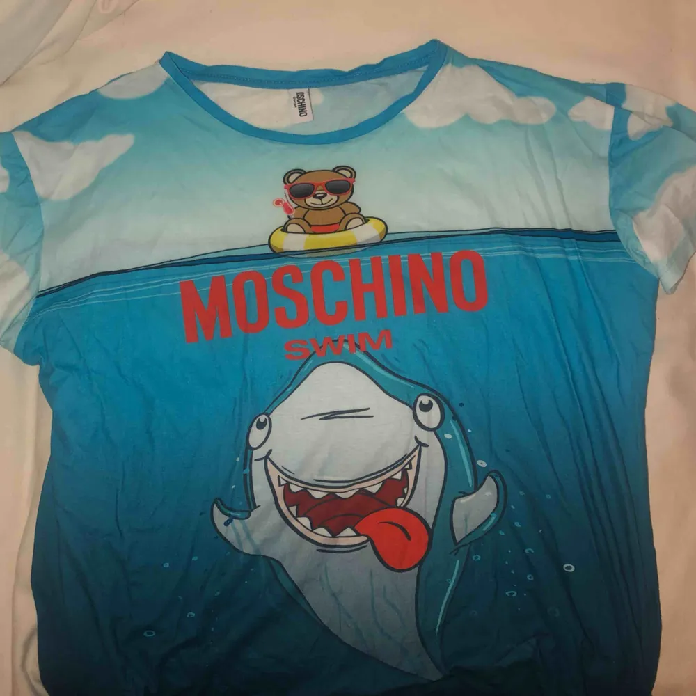 Supercool äkta Moschino-swim T-shirt. Inköpt i Italien för ca ett halv år sedan. Säljes pågrund av för stor! ANVÄND 0 GÅNGER. T-shirts.