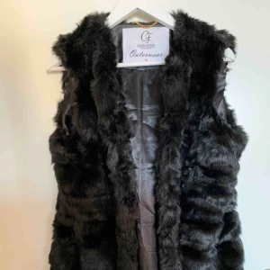  - Säljer en snygg pälsväst!  Storlek M Använd en gång Fejk päls  Kan knäppas med de gömda hakorna i västen Två fickor  Köparen står för frakten 70 kr 