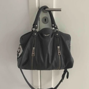  - Säljer grå Zadig et Voltaire väska ”Sunny Medium bag” storlek medium med måtten : 34 x 23 x 17.  Köpte den begagnat förr förra sommaren, knappt använd när jag köpte den och den är fortförande i mycket bra skick.