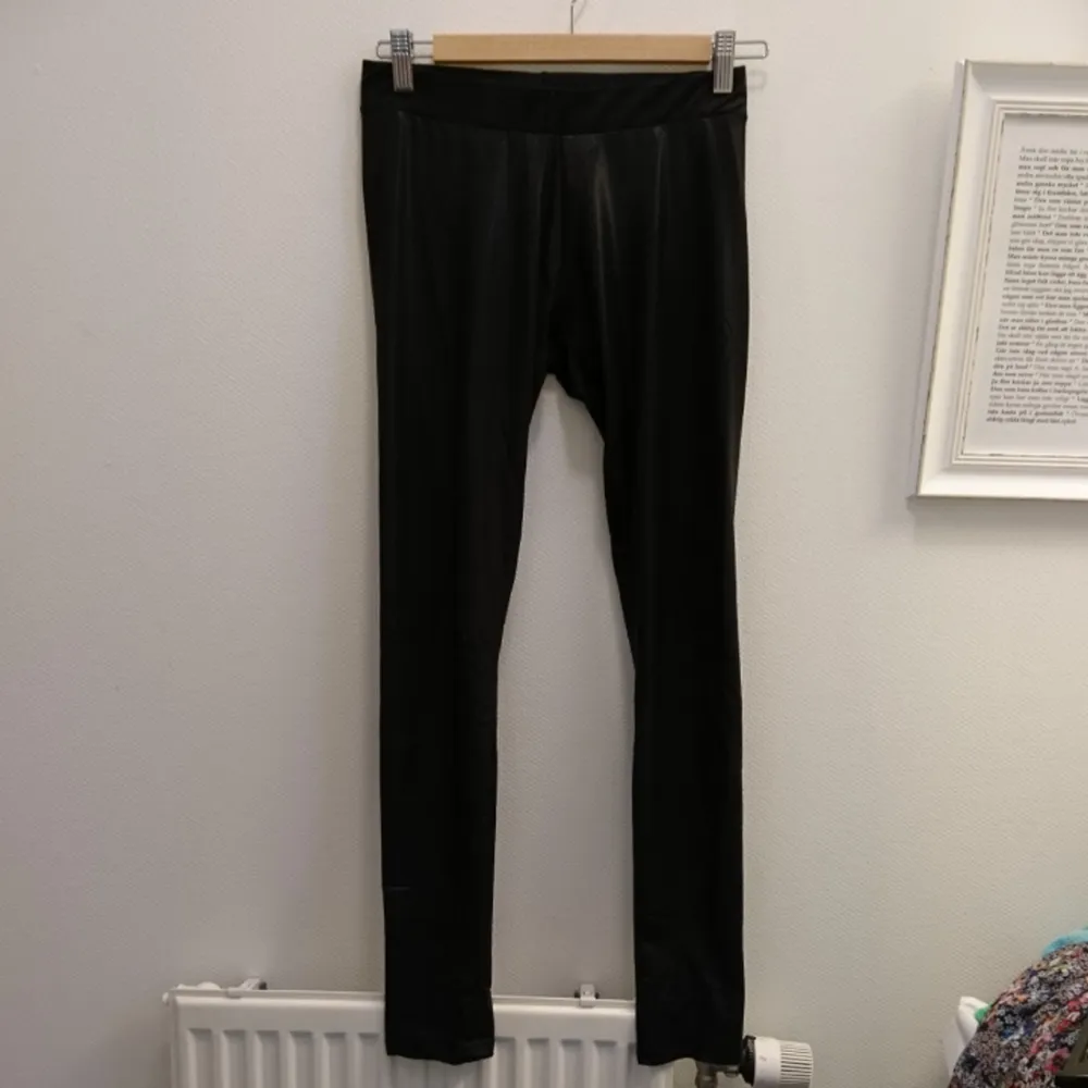 Svarta glansiga leggings. Passar till exempel till en festlig tunika eller klänning. 91% Polyester, 9% elastan. Maskintvätt 30°. . Jeans & Byxor.