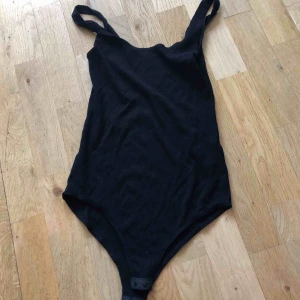  - En svart body. Vet ej storleken men skulle gissa på XS/s