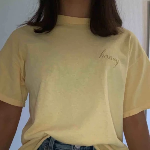  - Gul oversides t-shirt med honey broderi i Stl S. Har använts endast några gånger och är i fint skick. Köpt på Brandy Melville för 195kr. Frakten kostar 30kr och ingår inte i priset.  