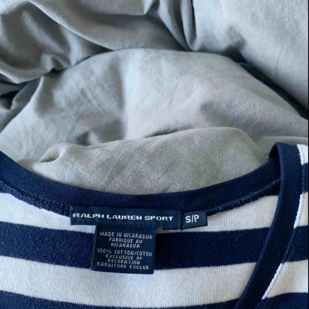 Blå-vit randig t-shirt med v-ringning från Ralph Lauren. Kommer aldrig till användning längre, därav säljer jag den. Tröjan är sparsamt använd och köparen står för frakten. Kontakta mig vid övriga frågor! :). T-shirts.