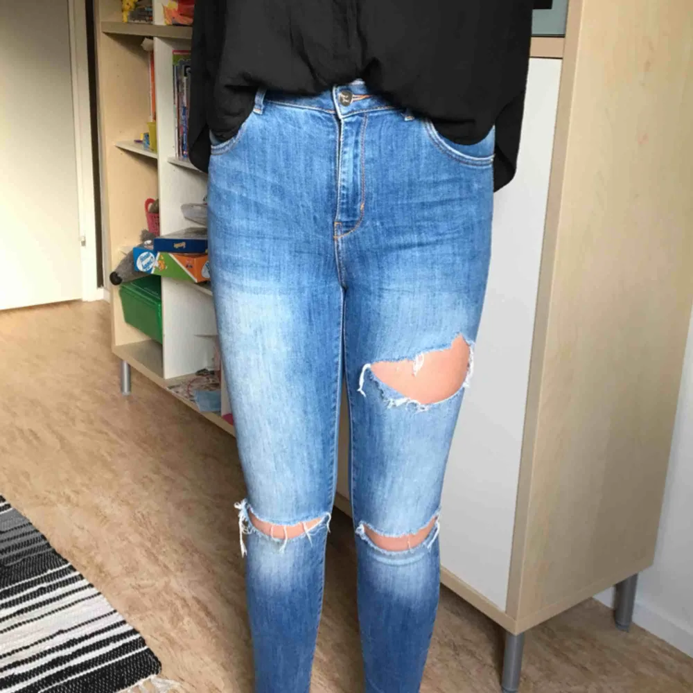 Trendiga rivna jeans. Dem har slitningar på lår, knän och fickor. De har hög midja och är i skinny fit. . Jeans & Byxor.