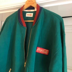  - Vintage Coca-Cola från 80-talet. Trevligt skick. Något liten så passar även som medium. Kan hämtas i Uppsala eller skickas mot fraktkostnad 
