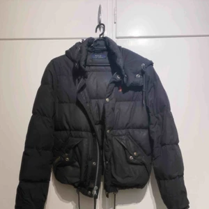  - En väl använd Ralph lauren jacka i storlek Large, passar alla storlekar då den går att anpassa med dragskor. Den skulle må bra av en tvätt men har även små rispor på vänster arm.  Där av det låga priset!