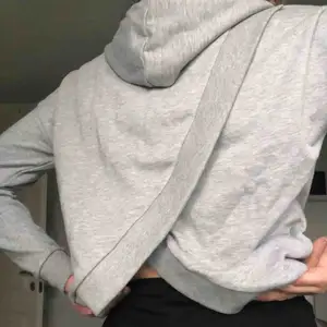 En grå hoodie med slits på ryggen. Har använt ungefär två gånger, bra skick. Frakt ingår ej i priset. 