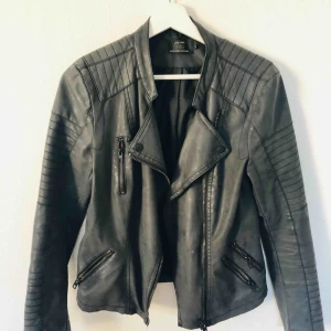  - Mörkgrå skinnjacka som sitter super snyggt på.  Storlek M 