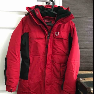  - En röd jacka från Fjällräven storlek Small. Jag tycker att den är ganska stor i storleken så även en Medium kan ha den. I mycket fint skick! Kommer från ett djur & rökfritt hem. Kan skickas mot portokostnad.