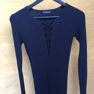  - Ribbstickad lång svart klänning med knytning framtill. Perfekt höst/vinterklänning! Supermjuk och skön. Använd 2 ggr. Från zara. Hämtas i Uppsala eller skickas mot frakt.