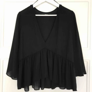  - Blus med djup v-ringning och 3/4 ärm 