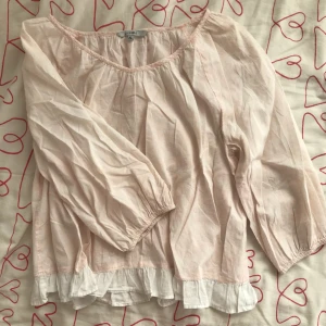  - ljusrosa blus med volang längst ner. är i storleken XL men skulle säga att den passar mer som en L/M. 